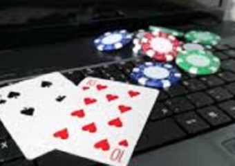 playing cards and casino chip on top of the keyboard